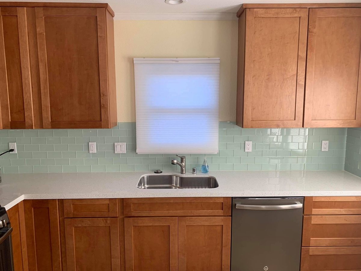 Kitchen with shaker cabinets and a glass subway tile backsplash by Matson General Contracting