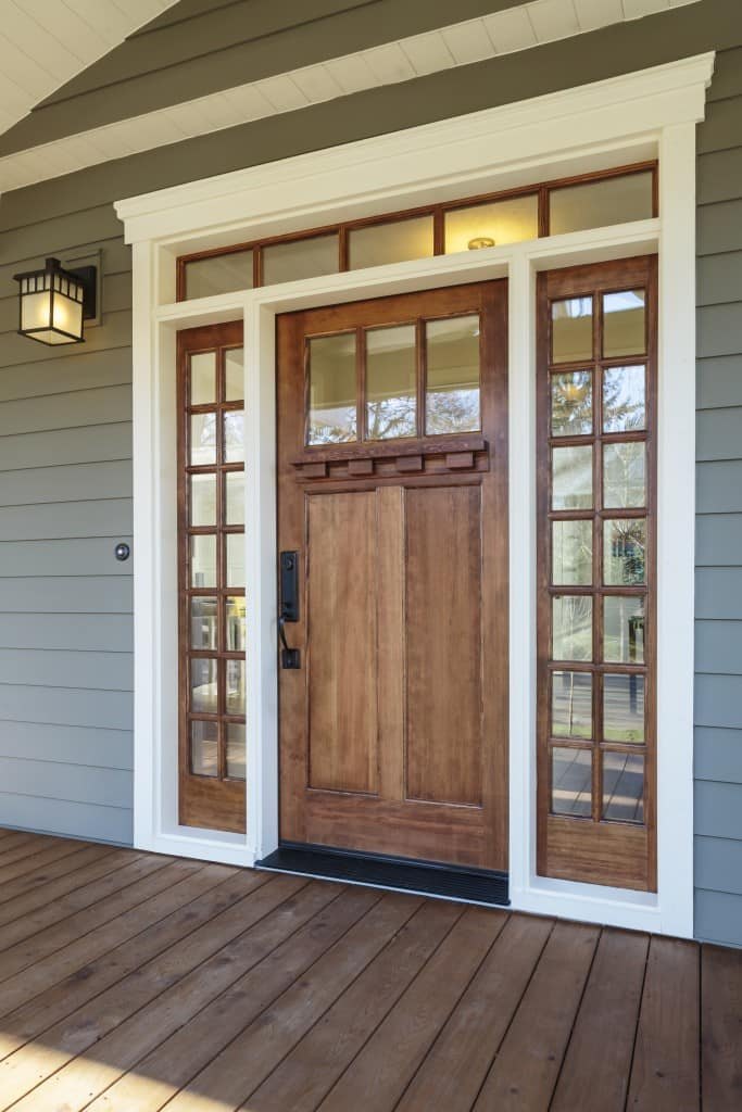 Craftsman-style wood entry door with glass sidelights and transom